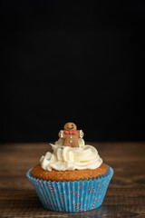 Individual Cupcake with Gingerbread Topper on Dark Background with Copy Space Vertical