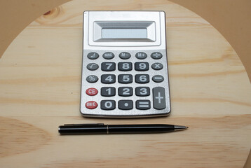 calculator  and pen near notepad on desk- office