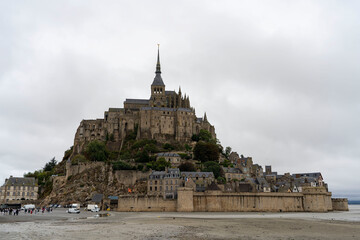 Abbey of Mont Saint Michel close-up, low tide and cloudy weather. Normandy, France.