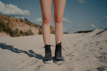 girl walking on sand. boots and legs. High quality photo