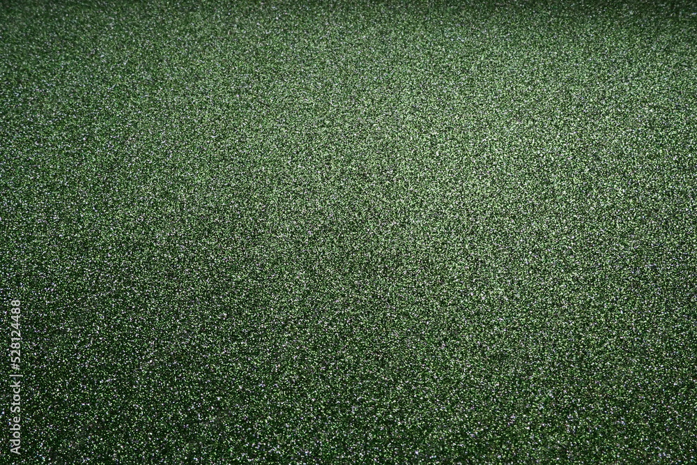 Poster deep grassy green. texture of rough paper or cardboard. defocused bokeh sparkles and shine on the fo