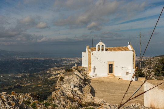 The little church of Afentis Christos on the top of Mount Giuchtas. In the background the city of Heraklion in Crete on a sunny day in December 2019