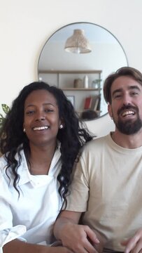 Vertical video.POV of a young multi-ethnic couple influencers making a video call or recording a vlog 