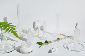 Laboratory glassware, Petri dishes and cosmetic glass bottles on white background. Natural...