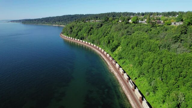 Ocean Shore Aerial View of Transport Train Riding Coastal Tracks