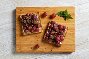 Overhead view of healthy toast with grapes and cream cheese.