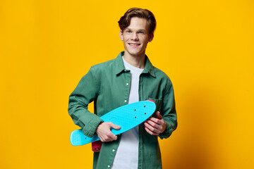 portrait of a happy man with a blue skateboard in his hands