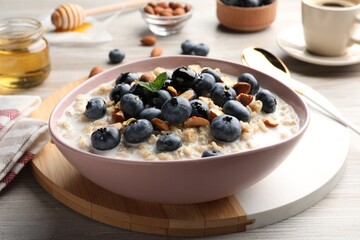 Tasty oatmeal porridge and ingredients served on wooden table. Healthy meal