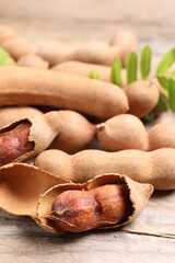 Delicious ripe tamarinds on wooden table, closeup