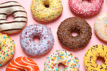 Delicious glazed donuts on pink background, flat lay