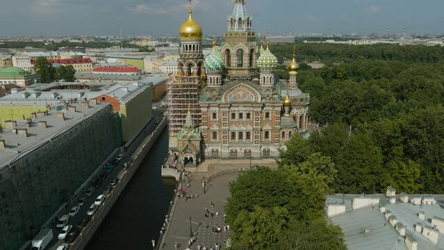 Aerial view of the Savior on Spilled Blood next to the street, under a river channel in the historical and at same time modern city of St. Petersburg at sunny summer afternoon