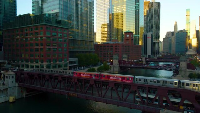 Chicago, IL USA September 1 2022: establishing aerial drone footage of  the Chicago downtown  train over the lake water during sunset. the city always moving during the course of the day