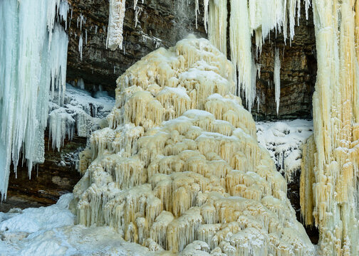 A peculiar, unusual beauty, ice stalagmite, consisting of many small icicles, in the limestone well of the Valaste waterfall, Estonia, which was formed during the period of severe winter frosts.