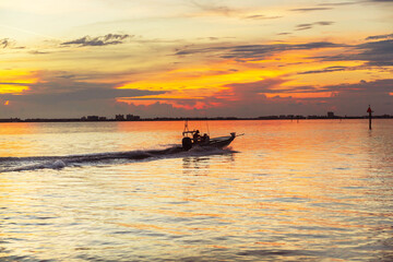 Naklejka premium Boat in the ocean bay at sunset