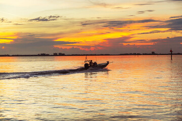 Boat in the ocean bay at sunset