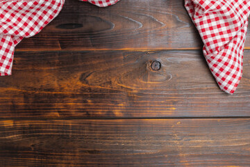 Top view textile a checkered red and white on the table wood. Checkered red and white on an old wooden background with copy space, flat lay, top view.