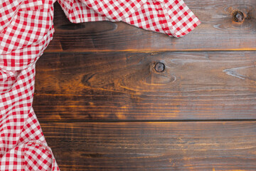 Obraz premium Flat lay, top view. Background of menu for the restaurant, copy space. Fabric red and white cover on the table. Checkered red and white tablecloth on an old wooden brown background with copy space.
