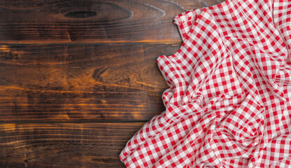 Fototapeta na wymiar Fabric texture background. Checkered red and white on an old wooden background with copy space, top view. The texture of the cotton fabric. With copy space for design menu of food for the restaurant.