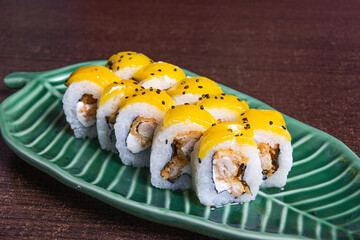 Tropical roll, Breaded chicken accompanied by cream cheese, rolled with fruit, bathed in passion fruit sauce.