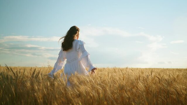 happiness and freedom in golden rye field, woman is running on ears of wheat, slow motion, swaying hair