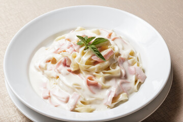 Creamy Fettuccine. Pasta with ham and parmesan on a white ceramic plate with Italian food - Imagen