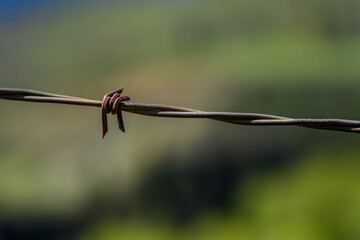 Closeup of barbed wire fence looking over the scenic Yakama River Valley
