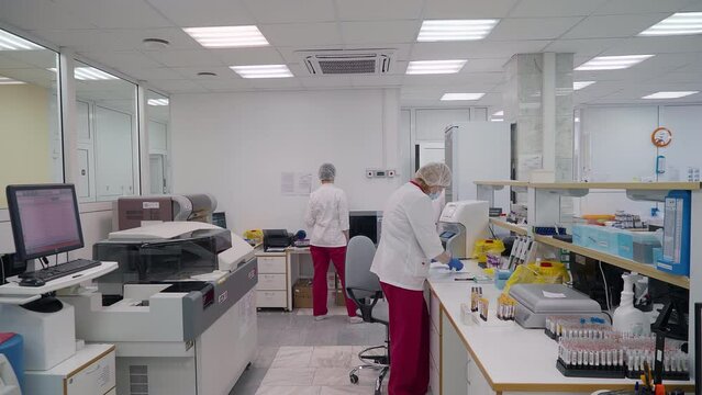 Specialists Examining Biochemistry Sample Tubes In Medical Laboratory At Clinic. Biochemistry Analysis For Blood Tests In Clinic Laboratory. Female Biochemistry Laboratory Researchers. Modern Clinic