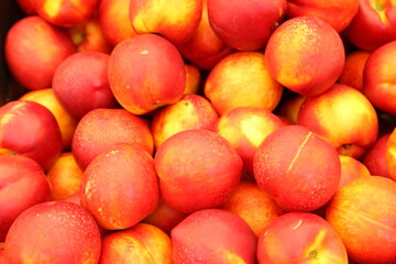 Lots of delicious looking very fresh peaches on sale at an outside market on a sunny Saturday.