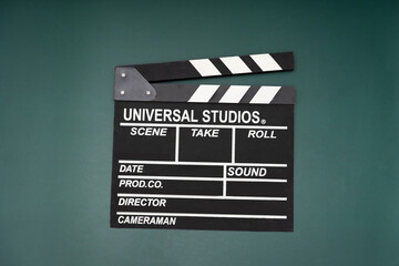movie clapper on green table background ; film, cinema and video photography concept