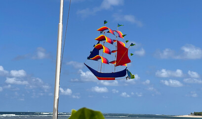 flying ship, rainbow colored ship kite flies on the blue sky and cloud - Powered by Adobe