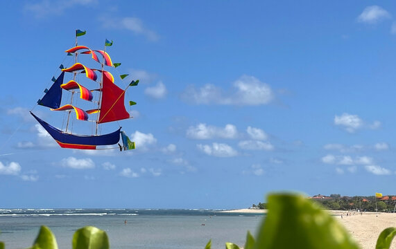 flying ship, rainbow colored ship kite flies on the blue sky and cloud