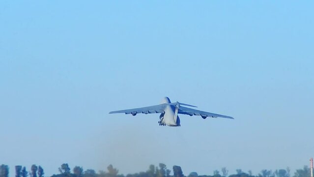 Avion militar de transporte de cargas de gran porte despegando al atardecer
