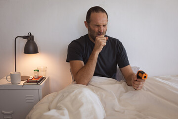 Sick Caucasian man self isolating and social distancing in quarantine lockdown during coronavirus co