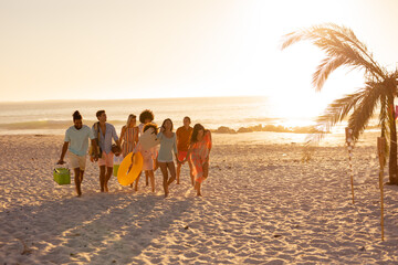 Mixed race friends group walking on beach