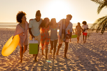 Mixed race friends group walking on beach