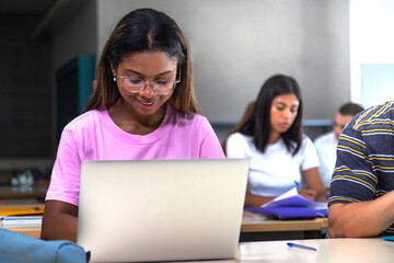 African american college student using laptop in class.Teen female black high school student doing...