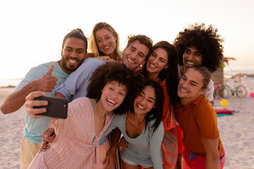Multi-ethnic group of male and female taking a selfie on the beach