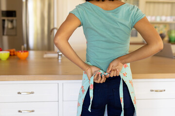 Young woman wearing apron in the kitchen