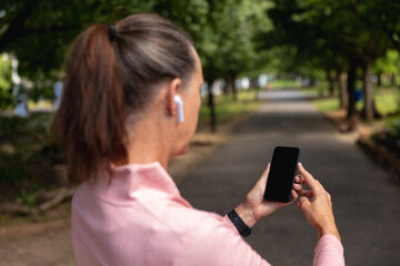 Female jogger using mobile phone in the park