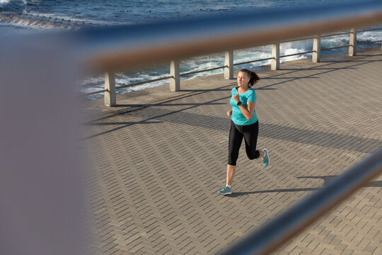 Female jogger running on seaside 