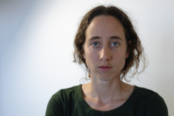 Portrait of Caucasian woman standing in an empty white room isolating and social distancing in quara