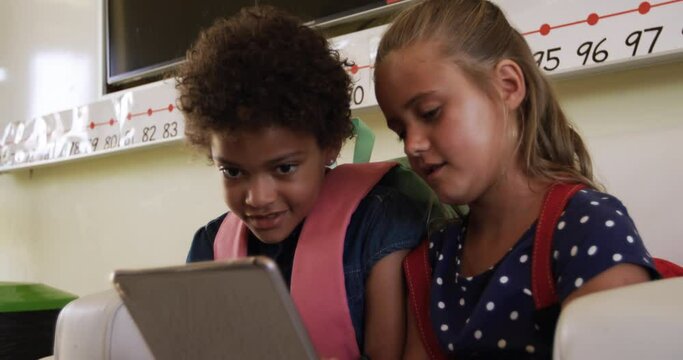 Two girls using digital tablet in the class