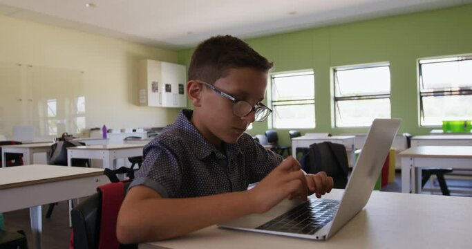 Boy using laptop in the class