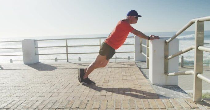 Senior man performing stretching exercise on the promenade
