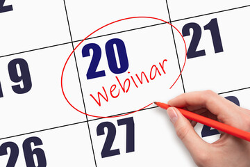 20th day of the month. Hand writing text WEBINAR and circling the calendar date.