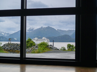 View through window of dramatic Alaskan scenery and passing cruise-ship
