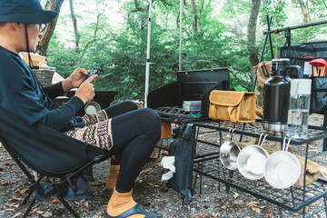 キャンプ場でスマホを見る男性
