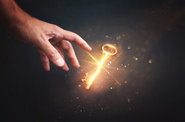 Male hand holding golden key with glowing light. Concept of success and wealth