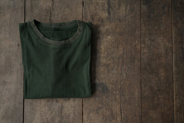 Green army t-shirt mockup over wooden background