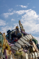 Pile of used trash on blue sky and clouds background.